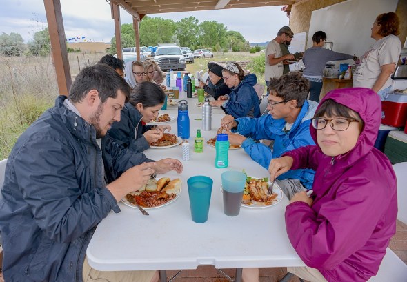 A morning monsoon drizzle dampens breakfast as students prepare for a wet day in the field.